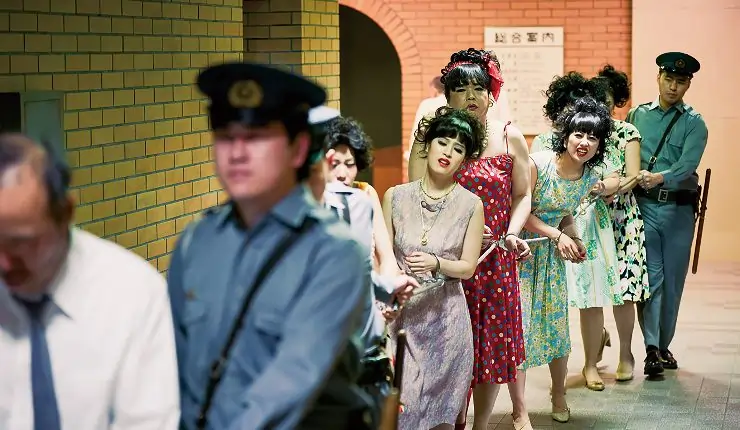 A group of woman and men chained together under arrest