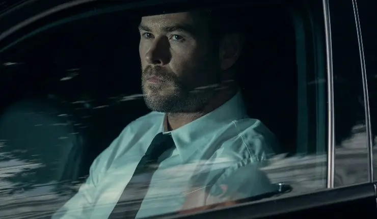 A man dressed smartly sits in a car watching someone, in Crime 101