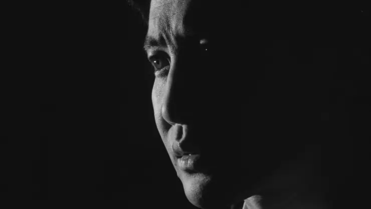 A Japanese man reflects in the dark.
