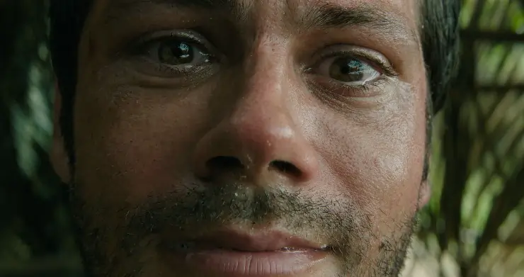 A close up of a man's face looks worried (Dylan O'Brien) in Get Help.