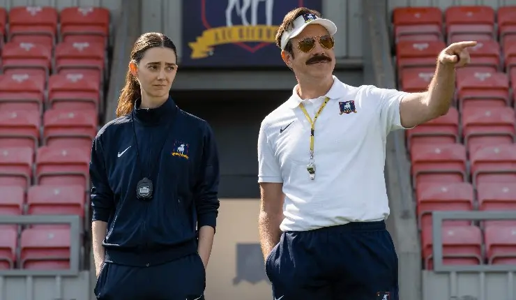 Ted Lasso stands side by side with one of his new coaches in Ted Lasso Season 4