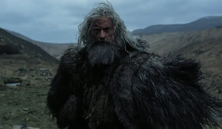An grey haired man in feathered clothing The Death Of Robin Hood