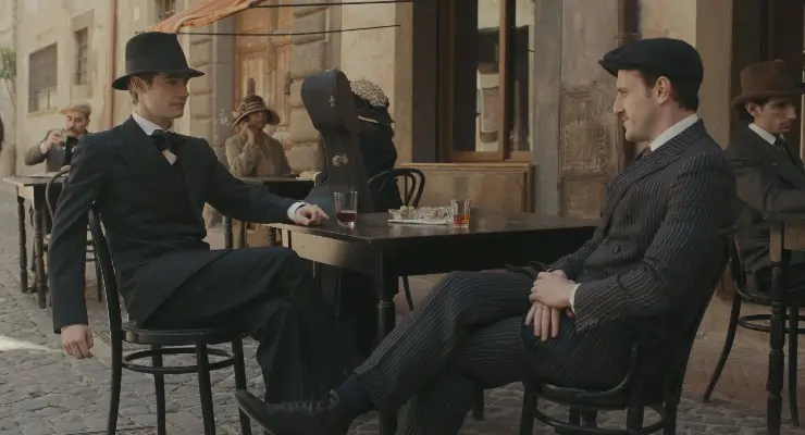 2 well dressed men enjoy a chat together at a cafe in The History Of Sound.