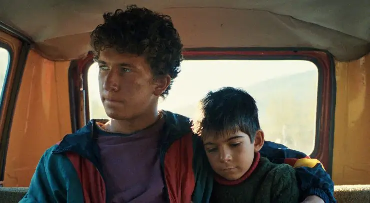 A young boy sits in back of a van with his brother in DJ Ahmet.