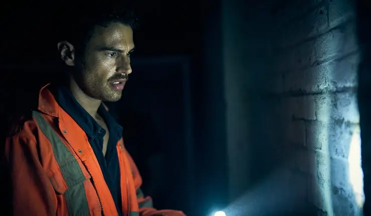 A man in a orange uniforms with a torch looks at something in Fuze.