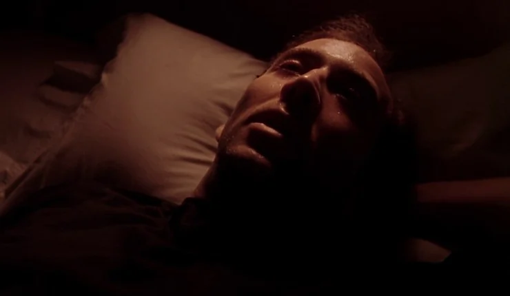 A man lies down on a bed in the dark in Leaving Las Vegas