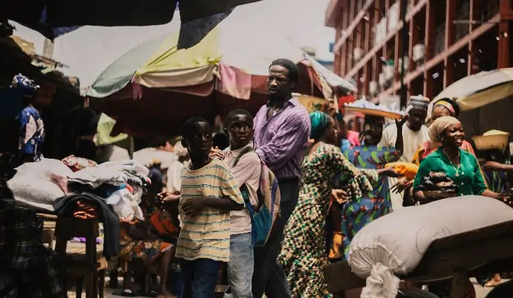 A man takes his sons through a busy market in My Father's Shadow coming to UK cinemas and MUBI.
