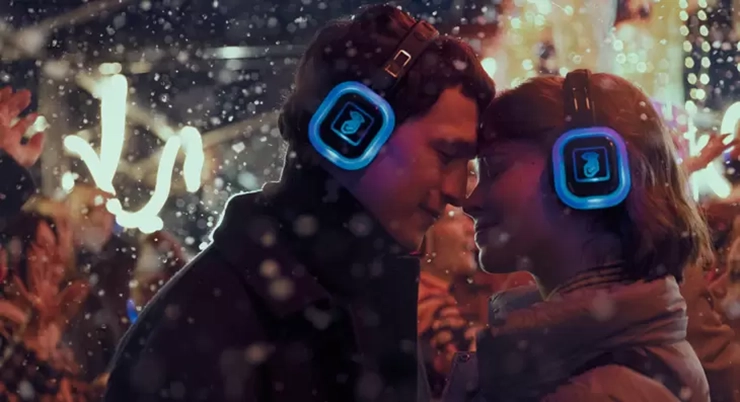 Two characters from the movie Photosensitive rest their heads against each other during a silent disco.