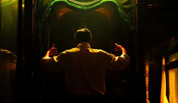 A man in the dark looks at a mirror in Bi Gan Resurrection.