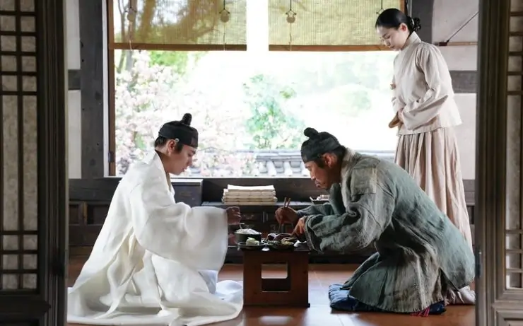 South Korean Period drama thriller, 2 men eat as a young female servant looks on in The King's Warden