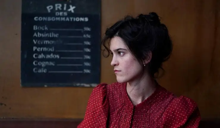 A woman in red sits in a bar starring at someone in Colours of Time