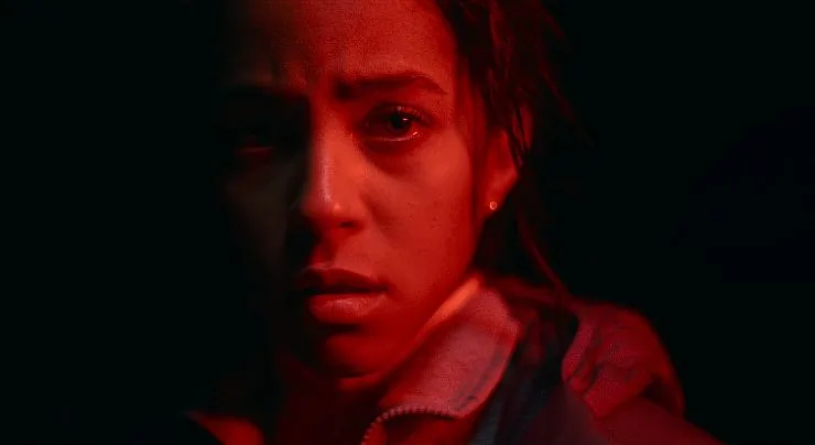 A scared woman illuminated by red light in Passenger.