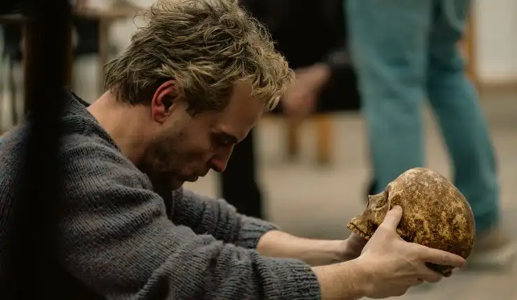 A man reflects holding a dirty Skull.