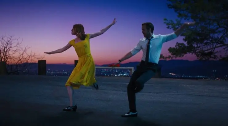 A woman in yellow dress and man in tie dancing in the famous Hollywood hill spot