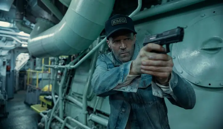 A man in a cap walks through a ship with a gun in Mutiny.