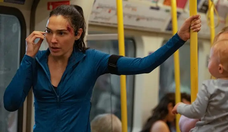 A woman on underground in blue looks anxious on a phone in The Runner.