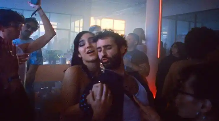 A woman and man in beard embrace each other in Club Kid