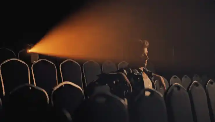 A young man sits in a cinema alone watching something in DOn't Forget Me.