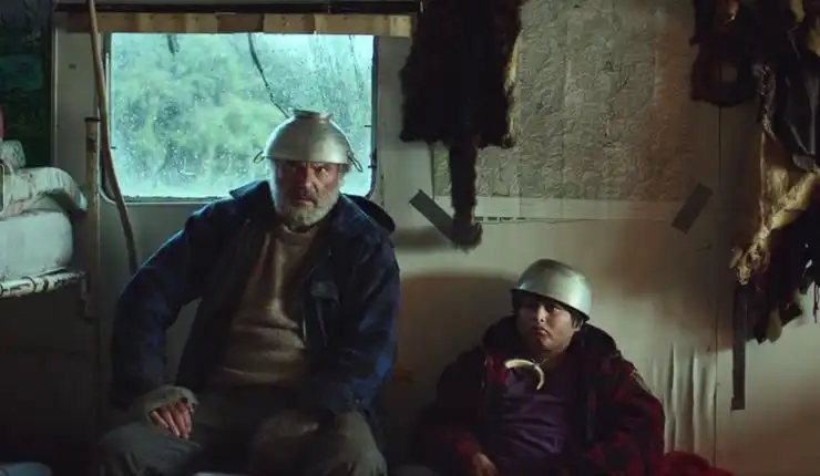 An older man and boy hide in a garage