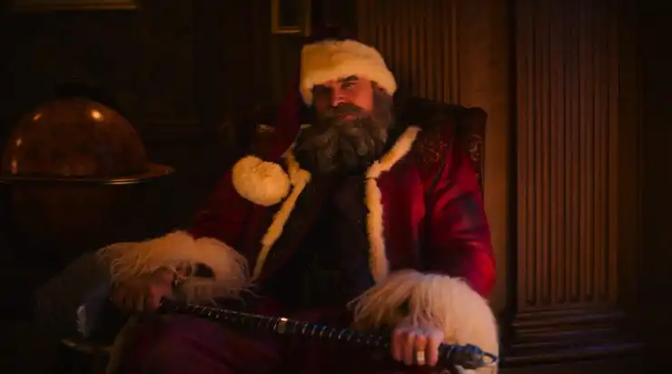 The Big man sits down with a weapon waiting for someone in Violent Night 2