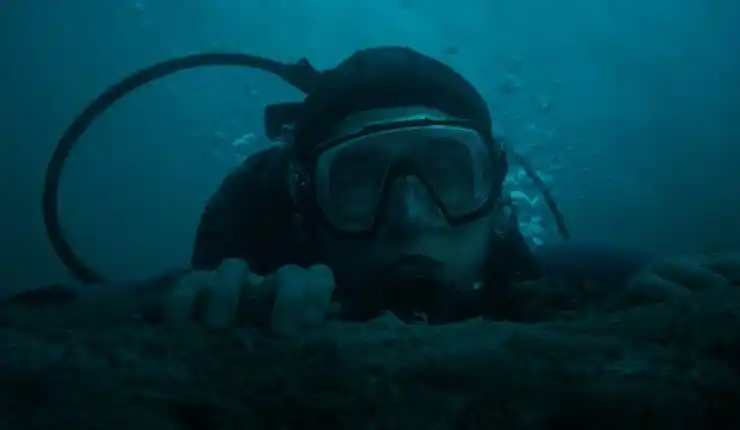 A man in scuba diving gear looks on in fear in Whalefall.