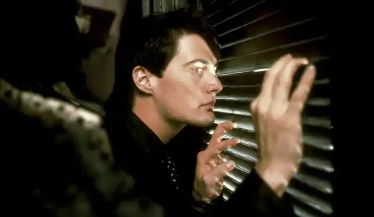 A young man looks through blinds in David Lynch's Blue Velvet