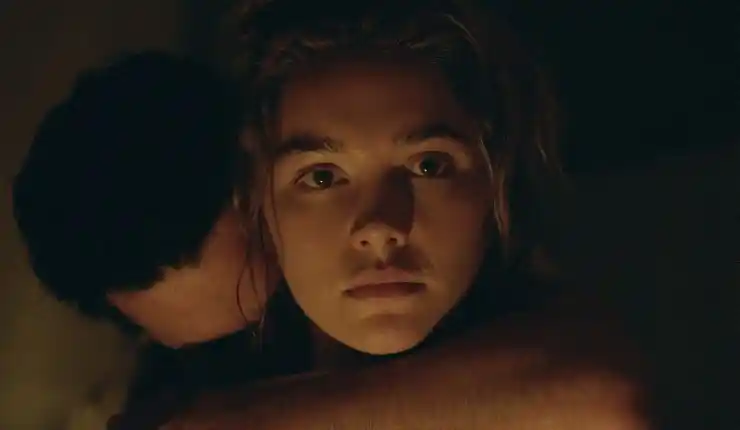 A young woman looks shocked as a man embraces her in East Of Eden