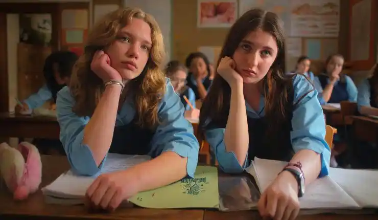 2 girls sit together in school drooling at someone in Extra Geography