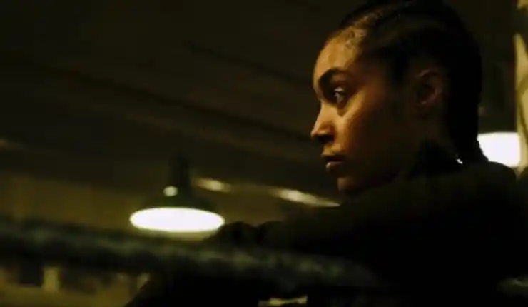 A woman reflects in a boxing ring in the shadows