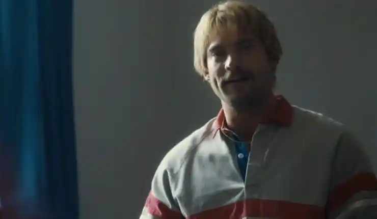 A man smiles as he listens to someone in Mr Irrelevant