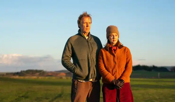 An older man and woman stand outside in the cold in Onwards and Sideways