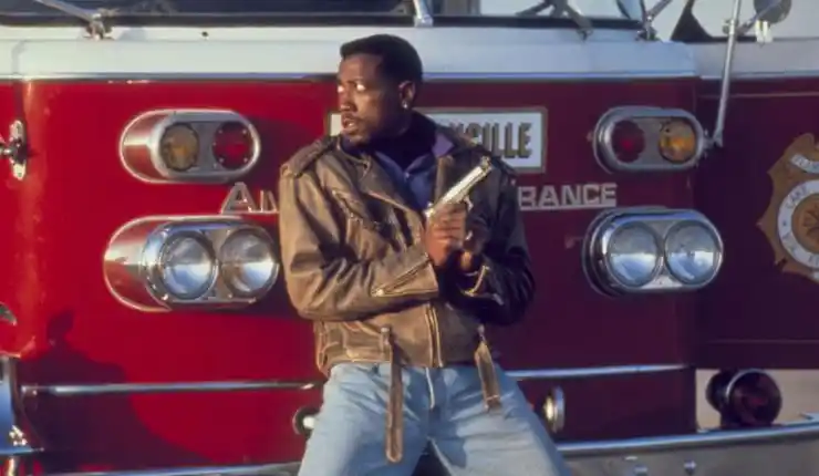 Wesley Snipes hides behind a fire engine with a gun in Passenger 57