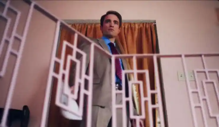 A suited man looks out from a door in Primetime