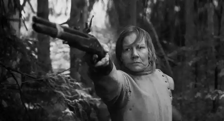 A war scarred woman fires a gun in Rose.