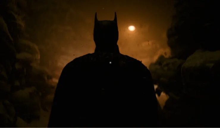 Robert Pattinson as Batman in a shadowy area