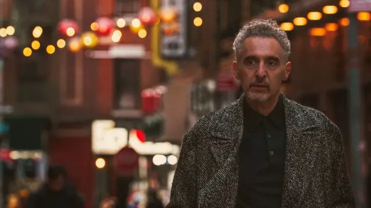 A man stands amidst a backdrop filled with lights