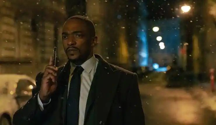 A man in a suit looking for someone in a dark street (12 12 12)