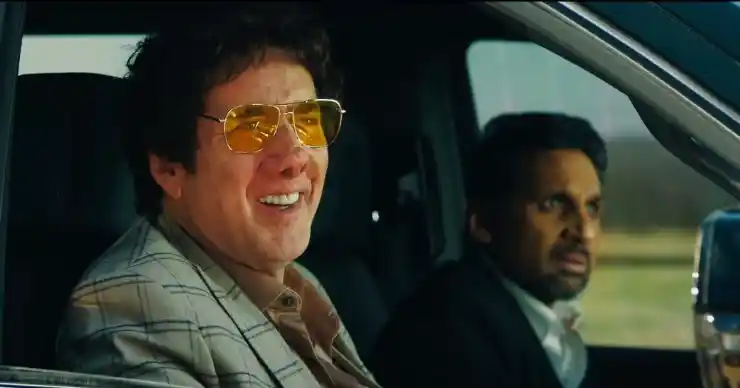A man with an odd nose smiles as driven in a car in Best Pancakes In The Country