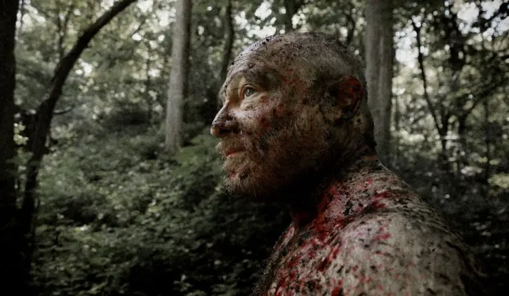 A muddy man stares out